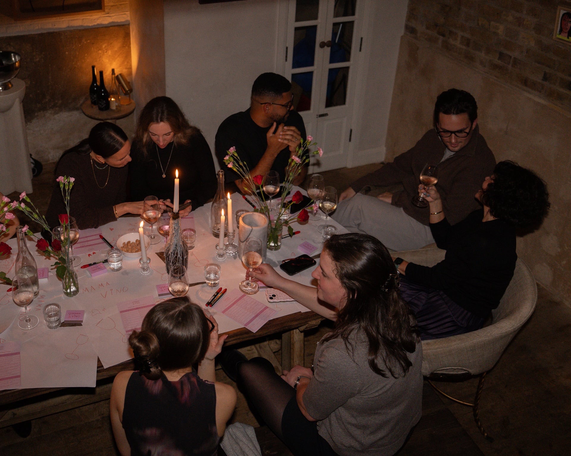 people around an candle-lit interactive table at a wine tasting event